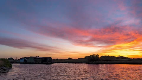 Quiet Sunrise Timelapse with sunray, sun, cloud colored and reflection in water Video stock 213976609