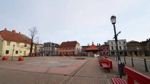Quiet wide shot of Cesis town square in Latvia with red benches, a lamp post Stock Footage 333417567