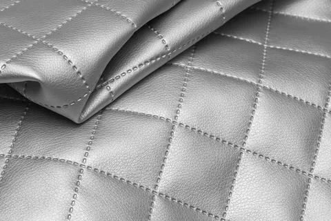 Quilted fabric sample with silver texture. Metallic leather background Stock Photos