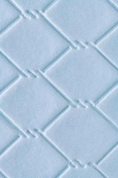 Quilted fabric texture with a diamond pattern in blue color, featuring a su.. Foto stock