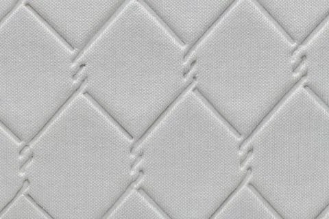 Quilted fabric texture with a diamond pattern in white color, featuring a s.. Foto stock