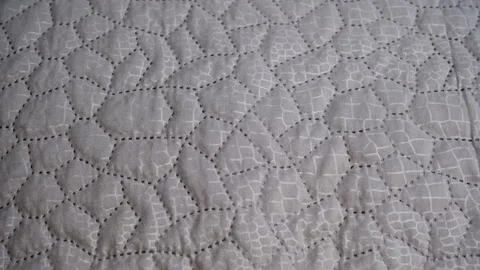 Quilted grey fabric creating an abstract geometric pattern Stock Footage 336116368