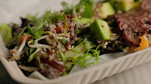 Quinoa salad with avocado, mango, and grilled beef in eco takeaway box Stock Footage 313053258