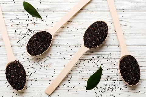 Quinoa seeds in spoon on colored background. Healthy kinwa in small spoon. He Stock Photos