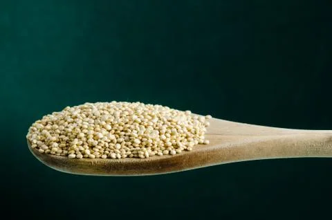 Quinoa in a spoon, close up, color background.. Stock Photos