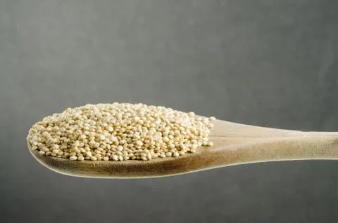 Quinoa in a spoon, close up, color background.. Stock Photos