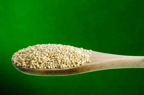 Quinoa in a spoon, close up, color background.. Stock Photos