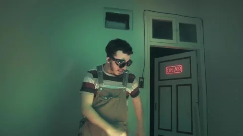 Quirky Guy in Goggles Dancing Live with Neon On Air Sign Stock Footage 340401379