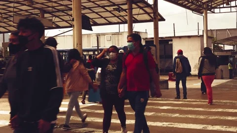 Quito, Ecuador 5-5-2021: People crossing a zebra path in a bus station Stock Footage 153722341