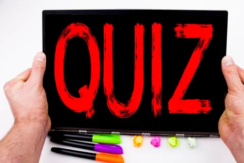 Quiz text written on tablet, computer in the office with marker, pen, station Stock Photos
