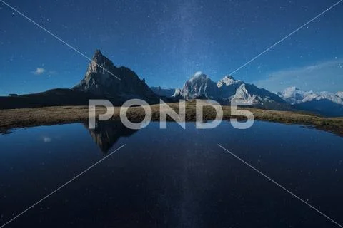 Ra Gusela reflects itself over a little alpine lake in Dolomites at night Stock Photos