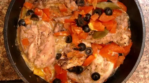 Rabbit Cacciatore Cooking in Cast Iron Pan on Stovetop Overhead View Stock Footage 132302953