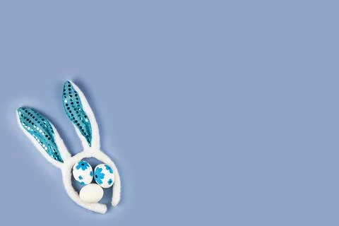 Rabbit ears and Easter eggs on a blue background. Easter decor. Stock Photos