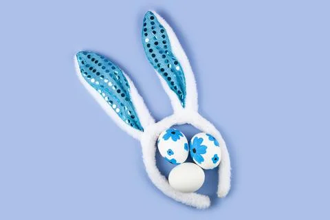 Rabbit ears and Easter eggs on a blue background. Easter decor. Stock Photos