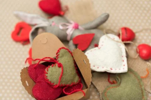 Rabbit handmade with red and white hearts lying on cardboard background in white Stock Photos