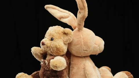 Rabbit with long ears and various teddy bears rotates on a black background, chi Stock Footage 147549172