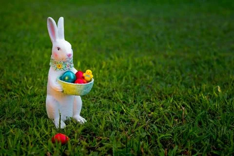 A rabbit souvenir with Easter painted eggs on the green grass. Little Bunny with Stock Photos