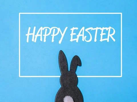 Rabbit is standing in front of a blue background with the words Happy Easter Stock Photos