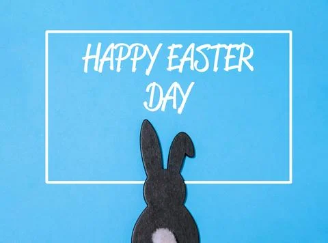Rabbit is standing in front of a white box with the words Happy Easter Day Stock Photos