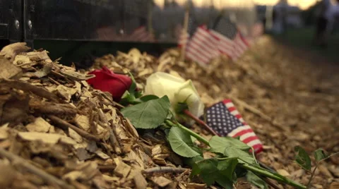 Rac focus close up of flowers and flags next to Vietnam Wall That Heals. Stock Footage 47392467