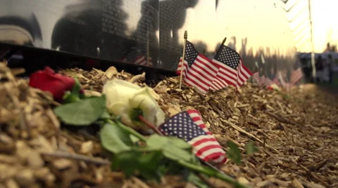 Rac focus from flags to flowers next to Vietnam Wall That Heals. Stock Footage 47393472