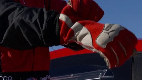 Race car driver puts on his glove on slow motion Stock Footage