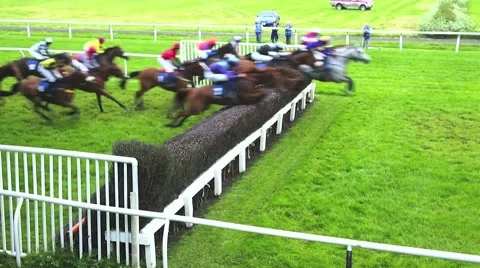 Racehorses jumping steeplechase fence - in normal time followed by slow motion Stock Footage