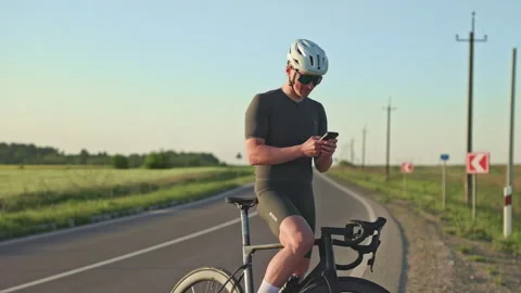 Racer scanning data on phone app about biking performance Stock Footage 247618939