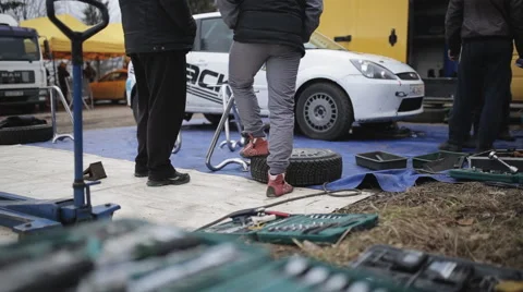 Racers watch performing services of their car in the service park Stock Footage 61745570