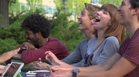 Racially-diverse students laugh at a table in slow motion. Stock Footage 44117343