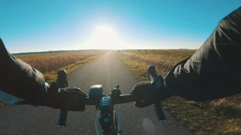 Racing bicycle point of view on a small road with sun shine in the horizon Video stock 98761639