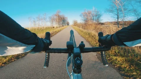 Racing biycle passing trees as it moves forward fast on autumn colored road Stock Footage 98765702