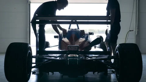Racing car is getting checked by two mechanics Stock Footage 162877170