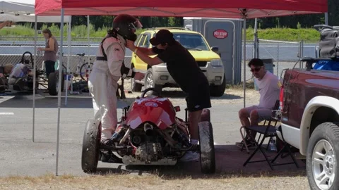 Racing car technician helping the driver to take off his helmet after racing. 스톡 동영상 157783960
