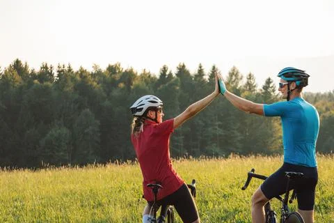 Racing cyclists looking at sunset over mountain tops, aerial shot Stock Photos