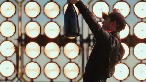 Racing driver pilot celebrates a win in a championship, standing on a podium Stock Footage 251319315