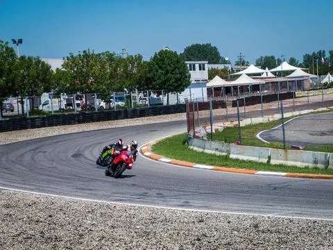 Racing driver on the track with his red bike Stock Photos