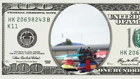 Racing drone taking off in frame of 100 dollar Stock Footage 97474279