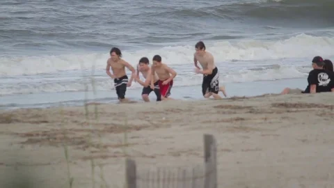 Racing group of boys on beach  Stock Footage 74477153