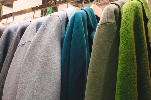 A rack of clothes with a green jacket on the top. The jacket is green and the Foto stock