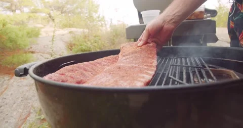 A rack of dry rubbed ribs being slow cooked and smoked on a kettle grill Stock Footage 159608076