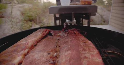 A rack of dry rubbed ribs being slow cooked and smoked on a kettle grill Stock-Footage 159608499