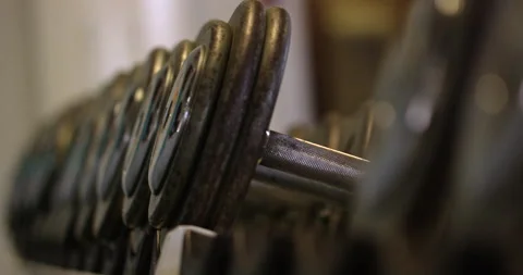 Rack of dumbbell weights in gym not being used - rack focus Stock Footage 148246536