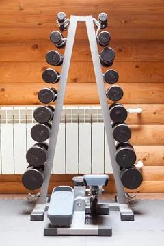 Rack with dumbbells and step machine in the room Stock Photos