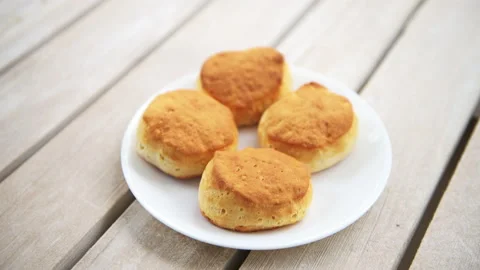 Rack focus on baked buttermilk biscuits on white plate Stock Footage 164667883