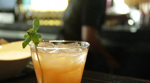 A rack focus of bar drink and bartender working in background Stock Footage 35403763