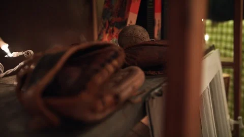Rack focus from a baseball mitt to a baseball on an antique store shelf Video stock 89496971