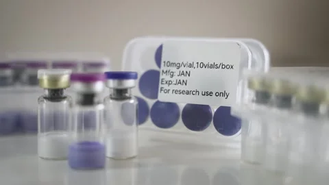 Rack Focus Between Pharmaceutical Vial and Research Use Only Label [Peptide Stock Footage 336203326