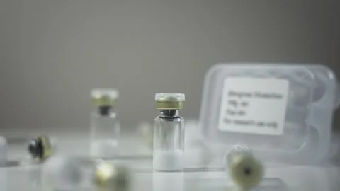 Rack Focus Between Single Pharmaceutical Vial and Storage Case [Peptide Concept] Stock Footage 336203320