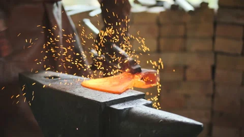 Rack focus blacksmith produces ax in his forge. close view of anvil, on which Stock Footage 161131205